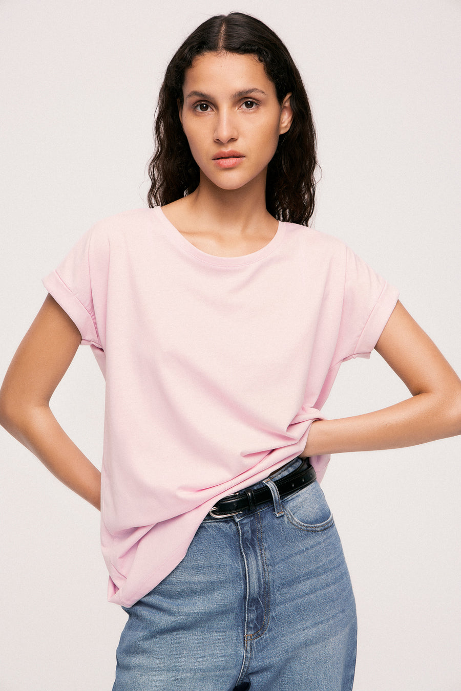 Roze T-shirt met korte mouwen van VILA, gedragen met een high-waisted jeans en een zwarte riem.