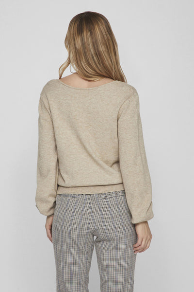 Pull beige de VILA, porté avec un pantalon à carreaux.