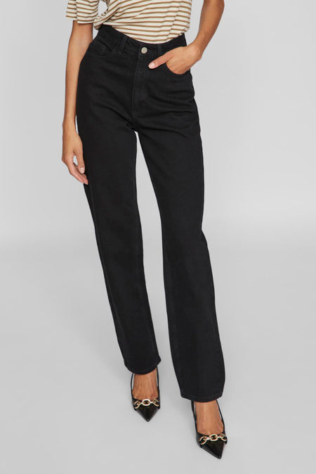 Jeans droit en jean noir de VILA®, taille haute, porté avec un t-shirt rayé et des chaussures plates noires à chaîne dorée.