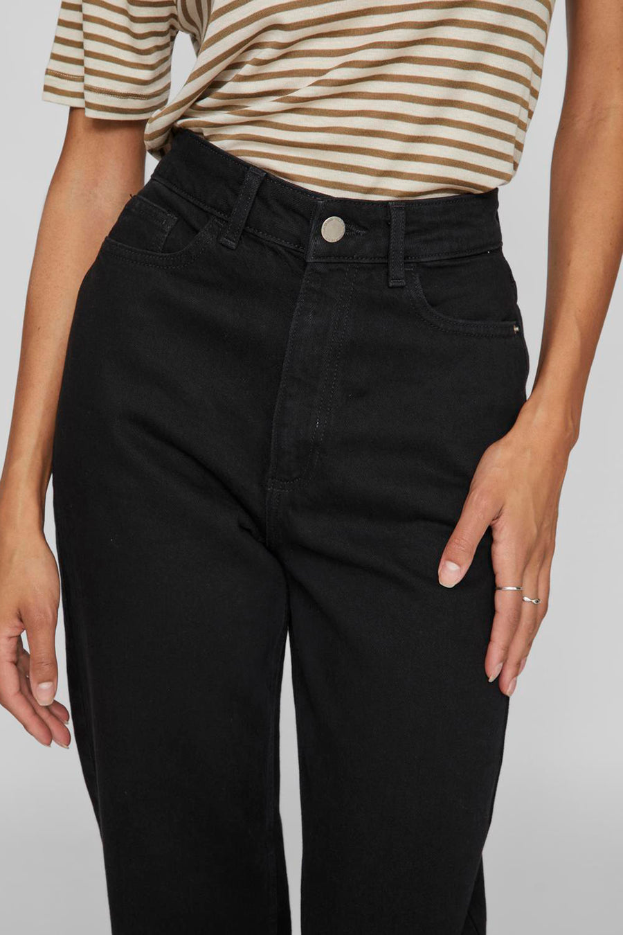 Zwarte straight jeans van VILA® in denim met hoge taille, met knoop en riemlussen, gedragen met een gestreept T-shirt en ringen.