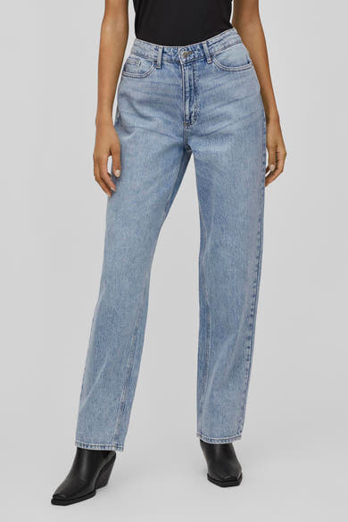 Wijde blauwe jeans van VILA, gedragen met zwarte enkellaarsjes met sleehak.