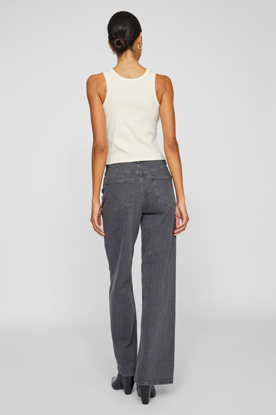Grijze wijde jeans van VILA, gedragen met een crèmekleurig hemdje en zwarte enkellaarsjes.