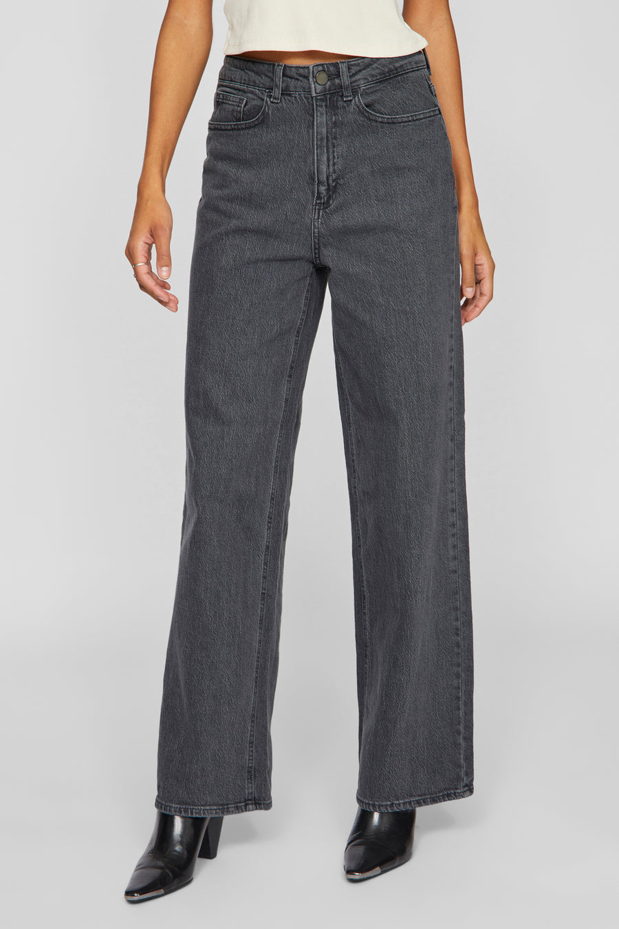 Grijze wijde jeans van VILA, gedragen met een crèmekleurige top en zwarte puntige enkellaarsjes.