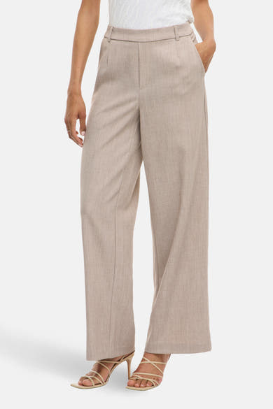 Beige broek van VILA®, rechte en losse pasvorm, met plooien aan de taille en sandalen met bandjes.