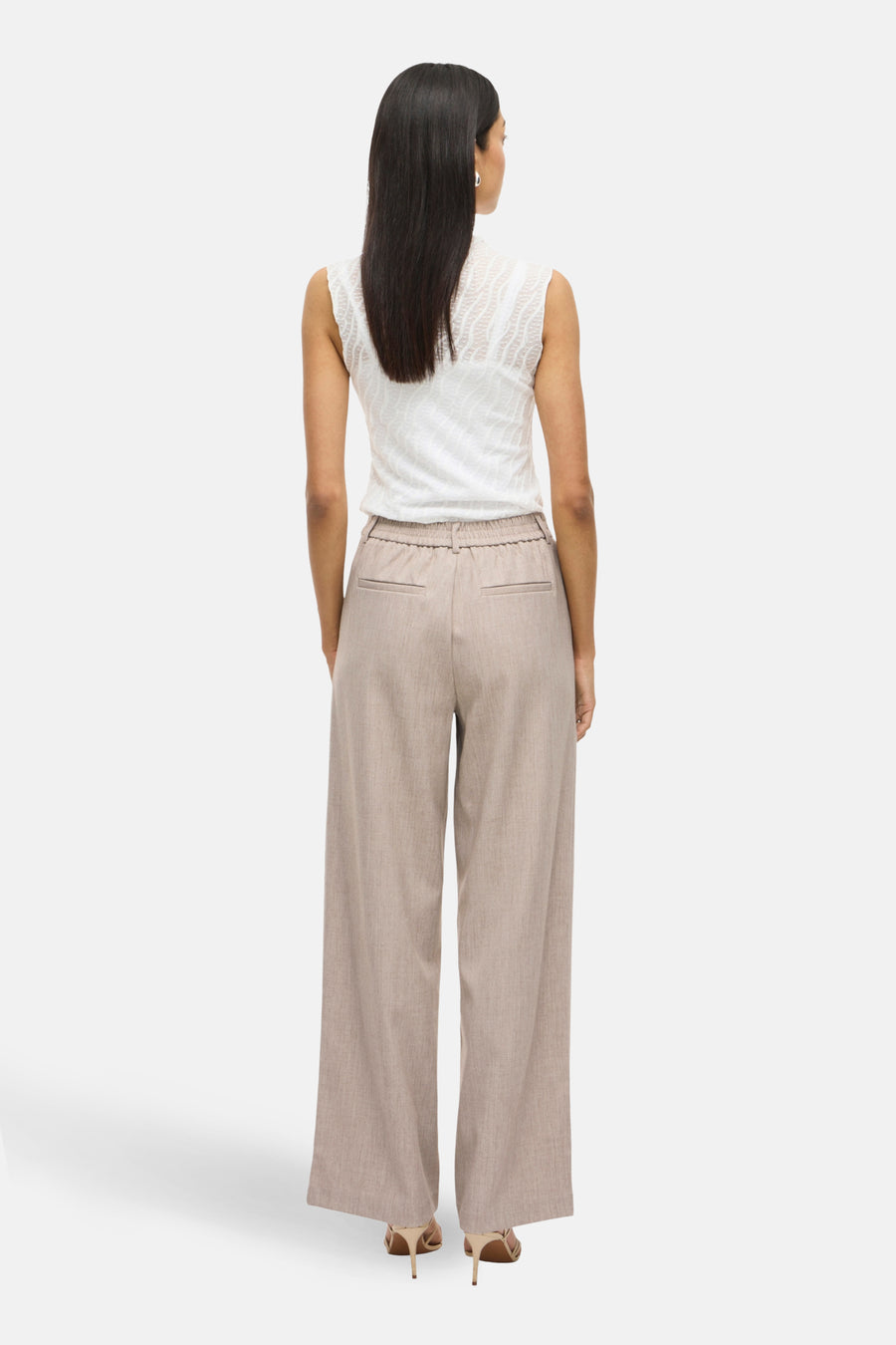 Beige broek van VILA®, met wijde pijpen en elastische taille, gedragen met een mouwloze witte top.