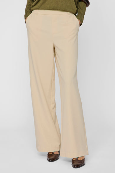 Pantalon beige de VILA®, coupe ample, porté avec des chaussures marron pointues.
