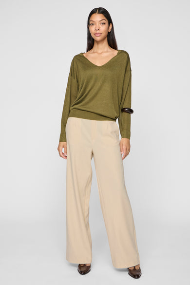 Pantalon beige de VILA, à jambes larges, porté avec un pull vert et des chaussures marron.
