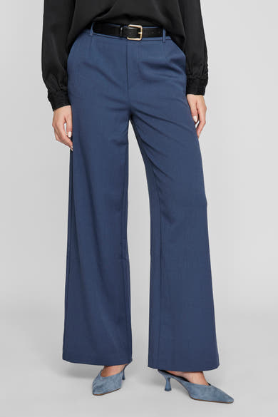 Pantalon bleu van VILA®, coupe ample et taille haute, porté avec une ceinture noire et un chemisier noir en dentelle.
