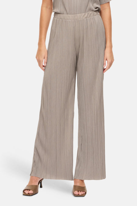 Taupe plooibroek van VILA®, gedragen met bruine muiltjes met blokhak.