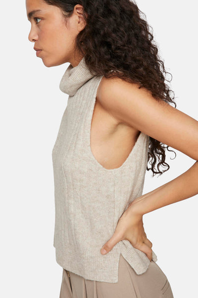 Beige geribd hemd zonder mouwen van VILA, met een opstaande kraag en mouwloze pasvorm, gedragen met een bijpassende broek.