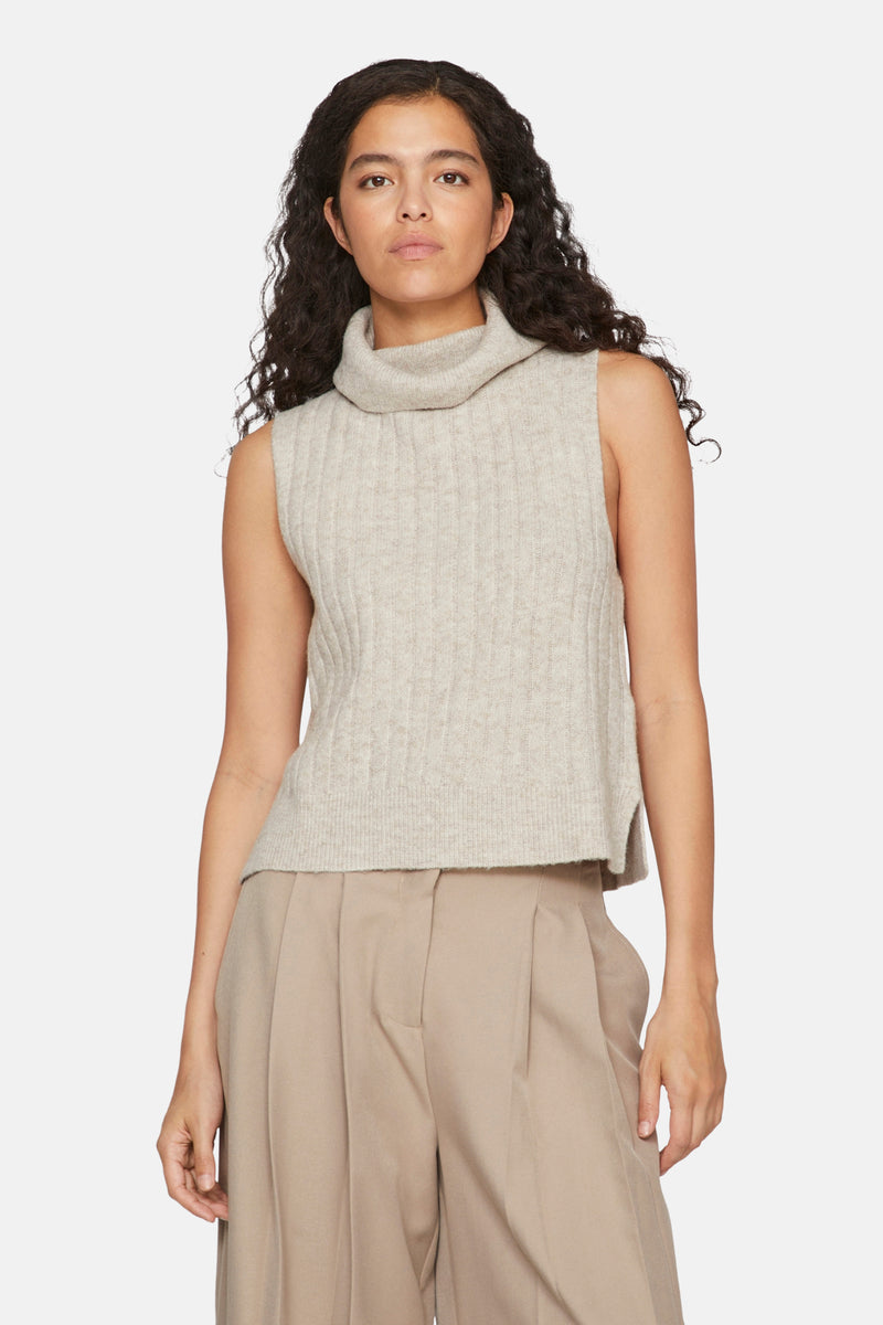 Beige hemd zonder mouwen van VILA®, in geribbelde gebreide stof met col, gedragen met een beige pantalon met plooien.