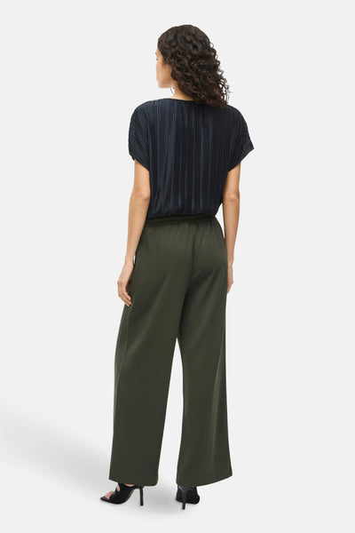 Pantalon vert de VILA®, ample avec une taille élastiquée, porté avec des escarpins noirs.