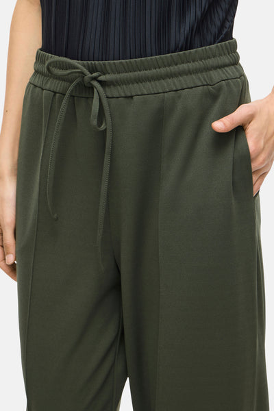 Pantalon vert de VILA, avec cordon de serrage à la taille et une main dans la poche.
