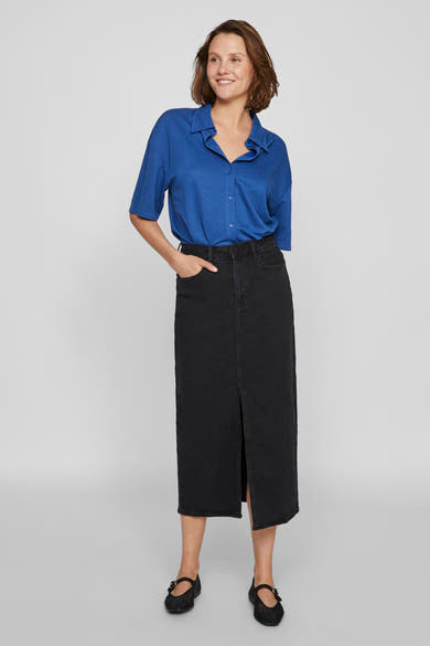 Zwarte midi-rok van VILA®, met een centrale split, gedragen met een blauw overhemd.