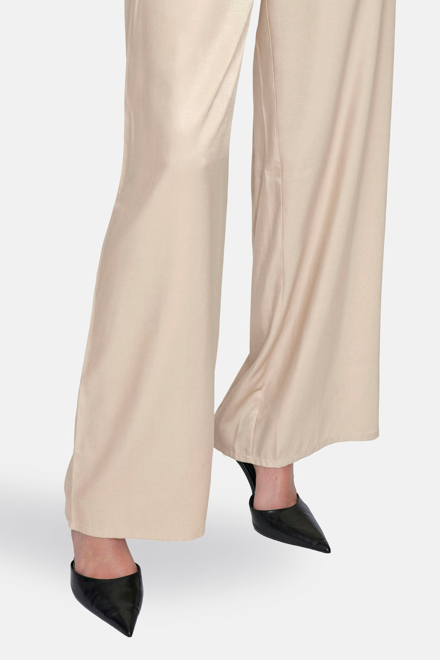 Beige broek van VILA®, losse en vloeiende pasvorm, gedragen met zwarte naaldhakken.
