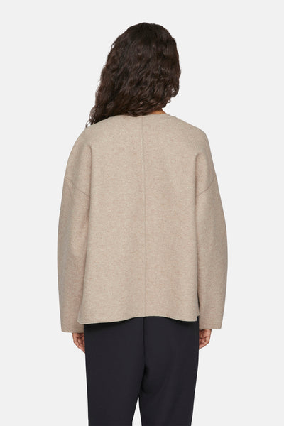 Veste courte beige de VILA, avec des manches amples et un ourlet droit, portée avec un pantalon noir.
