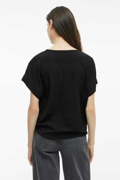 Zwart T-shirt met korte mouwen van VILA®, lichte textuur, gedragen met een grijze jeans, achtergezicht.