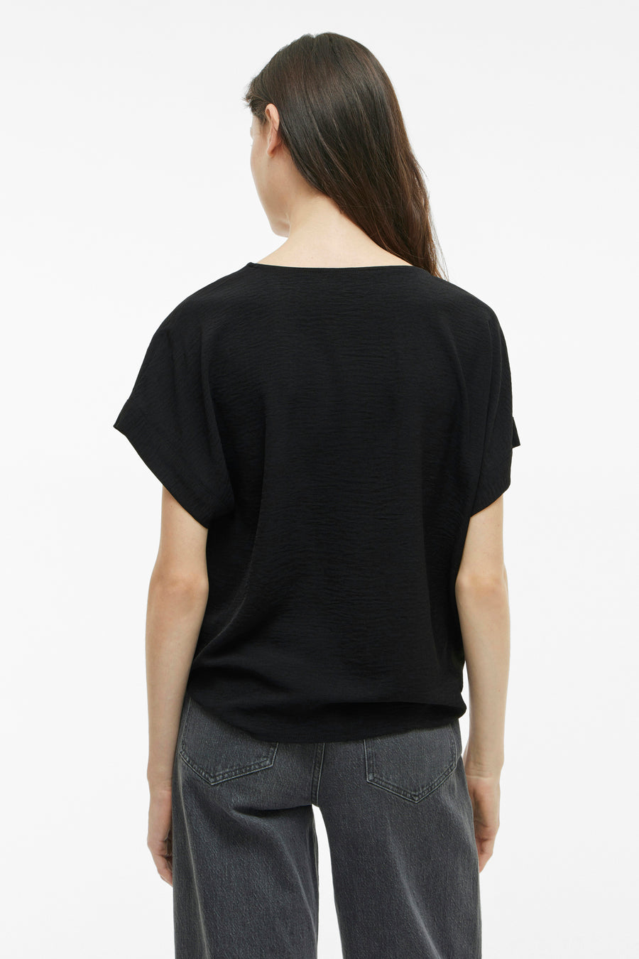 Zwart T-shirt met korte mouwen van VILA®, lichte textuur, gedragen met een grijze jeans, achtergezicht.