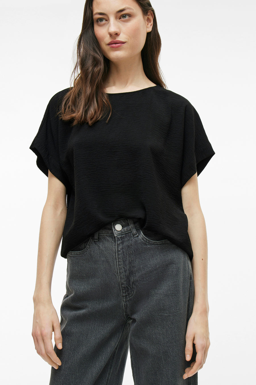 Zwart T-shirt met korte mouwen van VILA, gedragen met een donkergrijze high-waist jeans.