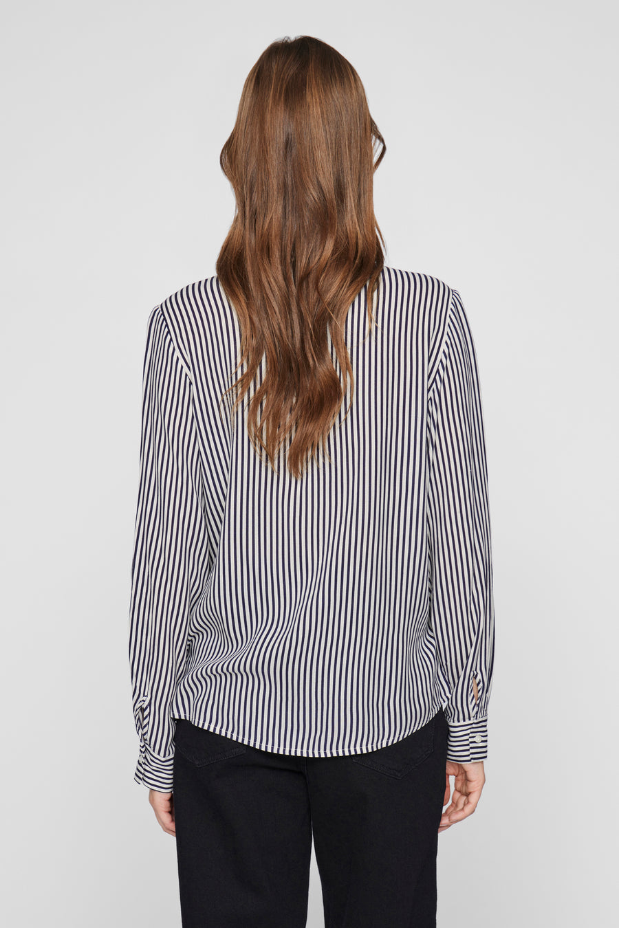Blouse met lange mouwen blauw van VILA, verticale strepen, gedragen met een zwarte broek, achterzicht.