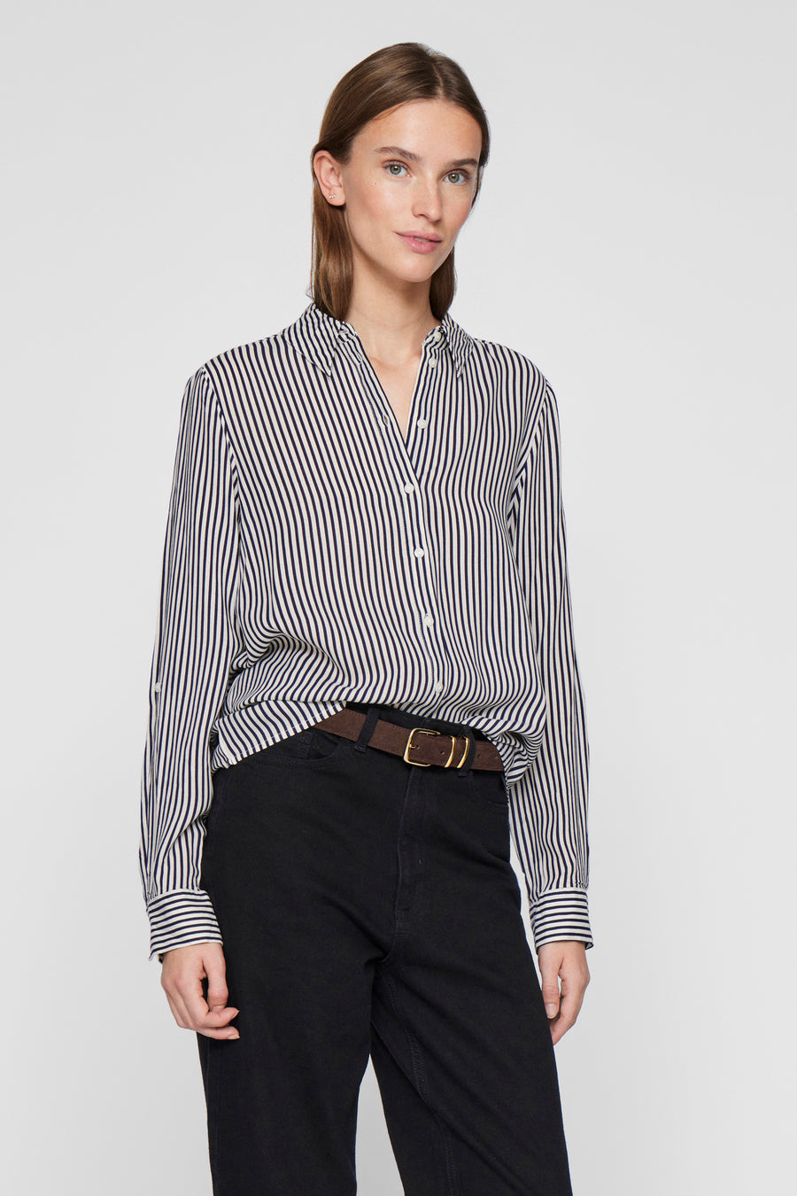 Blouse met lange mouwen in blauw gestreept van VILA, gedragen met een bruine riem en een zwarte broek.