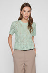 Groene trui met ronde hals in opengebreide stof van VILA, gedragen met een beige broek met hoge taille.
