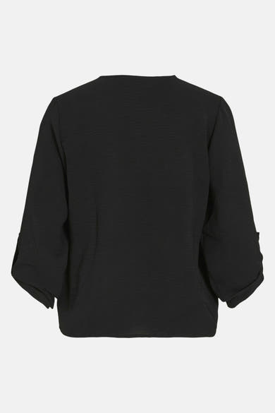 Blouse noire à manches longues de VILA®, texture subtile et manches 3/4 retroussées.