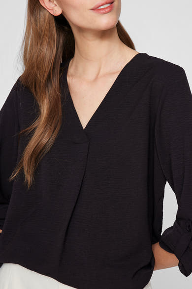 Zwarte blouse met lange mouwen van VILA, met een gekruiste V-hals en een asymmetrische zoom.