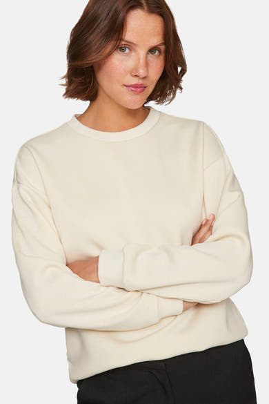 Beige ronde hals sweatshirt van VILA, met lange mouwen en rechte zoom, gedragen met een zwarte broek.