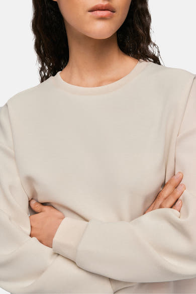 Beige ronde hals sweatshirt van VILA, lange mouwen en zachte textuur op lichte achtergrond, gekruist lichaam de armen.