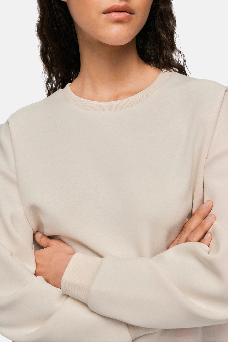 Beige ronde hals sweatshirt van VILA, lange mouwen en zachte textuur op lichte achtergrond, gekruist lichaam de armen.