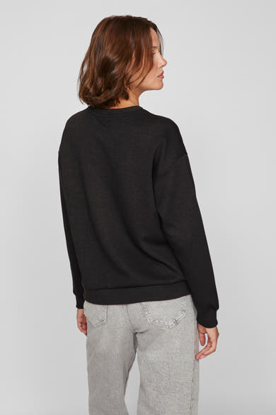 Zwarte trui met ronde hals van VILA, gedragen met een grijze jeans, achterzicht.
