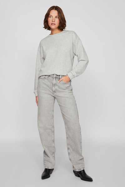 Sweat-shirt gris par Vila, porté avec un jean taille haute délavé et des bottines en cuir noires.