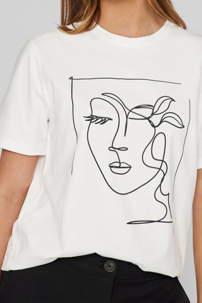 T-shirt blanc à manches courtes de VILA®, orné d'un dessin au trait noir d'un visage féminin et porté avec un pantalon noir.
