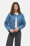 Kort jasje van middieblauw denim van VILA, met zilveren knopen en gedragen over een wit T-shirt.