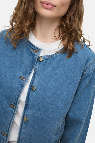 Kort jasje van middieblauw denim van VILA, met zilverkleurige knopen en een klassieke denimtextuur.