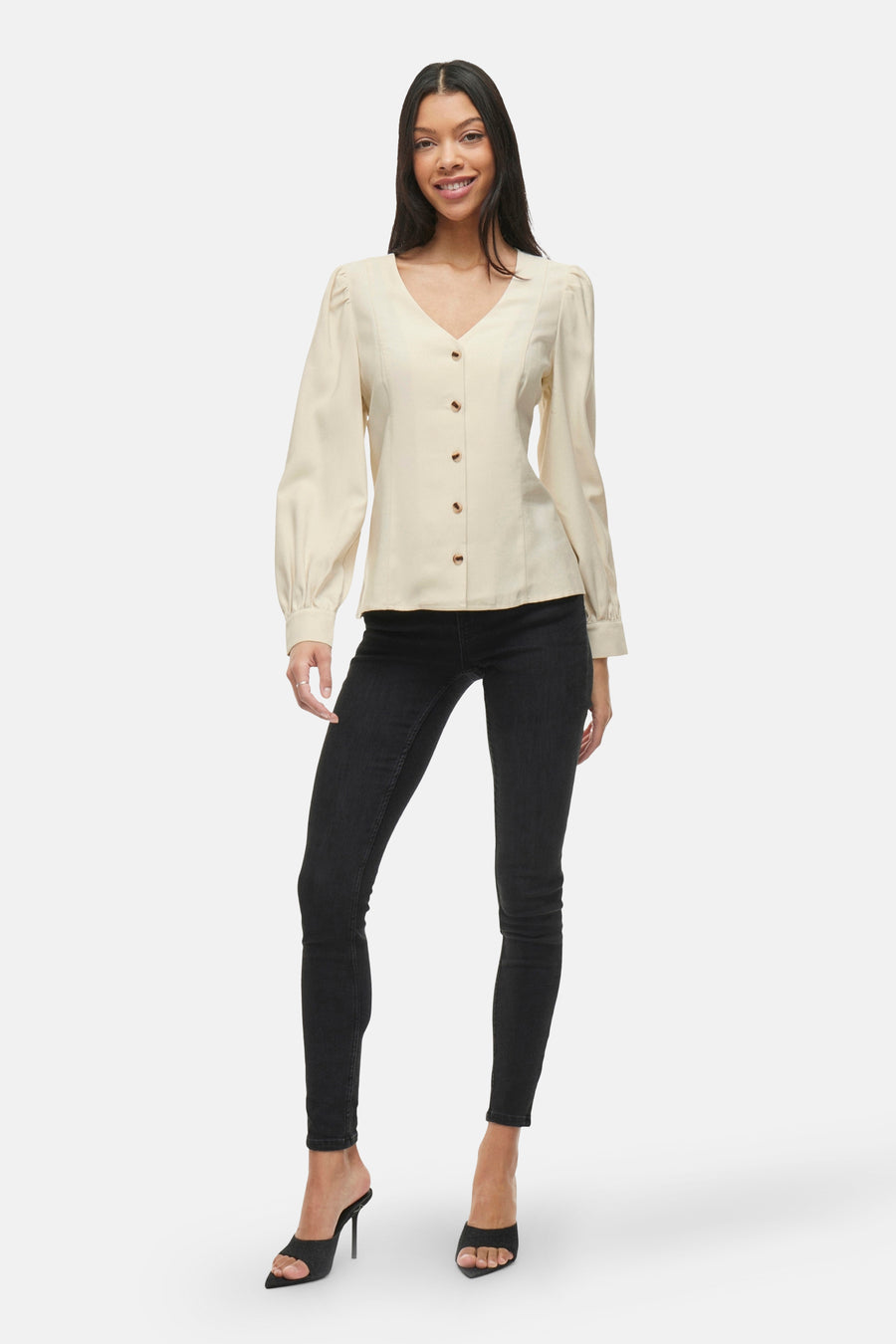 Beige blouse met lange mouwen van VILA®, met decoratieve knopen en gedragen met een zwarte jeans en hoge hakken.