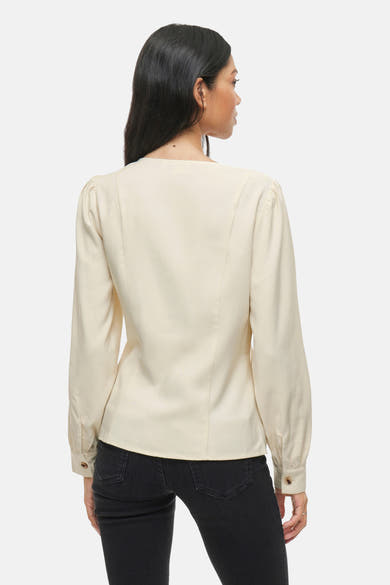 Beige blouse met lange mouwen van VILA, van achteren gezien, gedragen met een zwarte jeans.