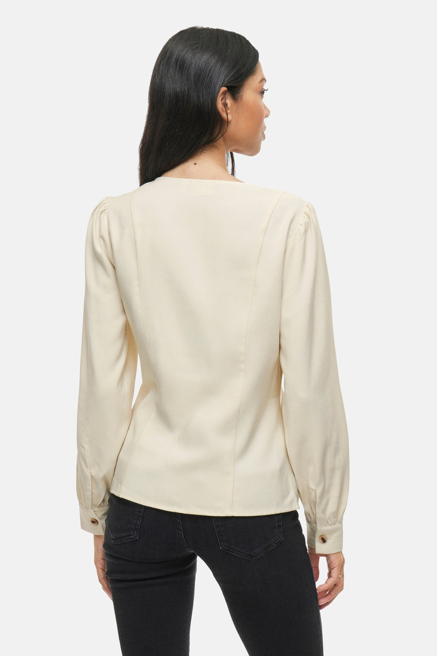 Beige blouse met lange mouwen van VILA, van achteren gezien, gedragen met een zwarte jeans.