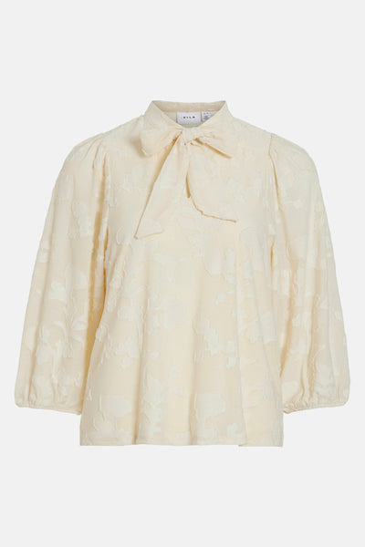 Blouse écrue à manches longues de VILA ornée d'un motif floral en relief et d'un nœud au col.
