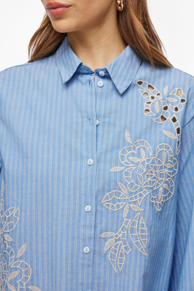 Chemisier bleu à rayures de VILA®, orné de broderies florales ajourées.
