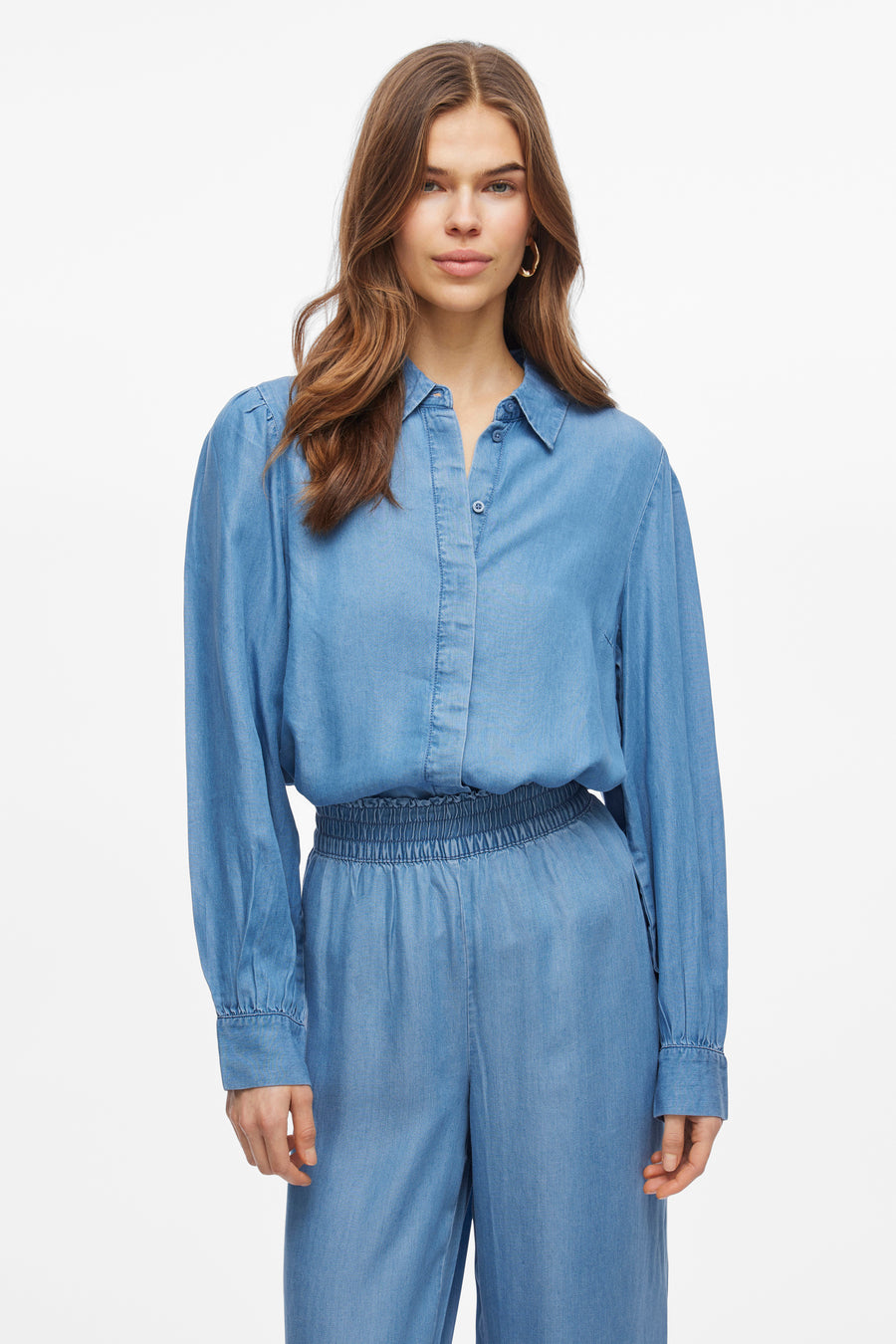 Chemisier en denim bleu à manches longues de VILA, avec col boutonné et détail élastique à la taille.