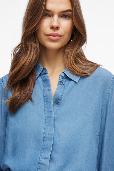 Middelblauwe spijkerblouse met lange mouwen van VILA, met knoopsluiting en subtiele textuur.