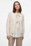 Beige gilet van VILA®, gedragen over een blouse met strik en een zandkleurige broek.