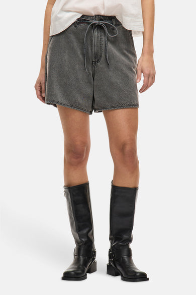 Short gris de VILA, porté avec des bottes hautes en cuir noir et un t-shirt blanc.