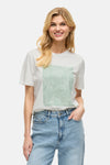 T-shirt à manches courtes blanc de VILA®, avec imprimé graphique abstrait sur le devant, porté avec un jean bleu.
