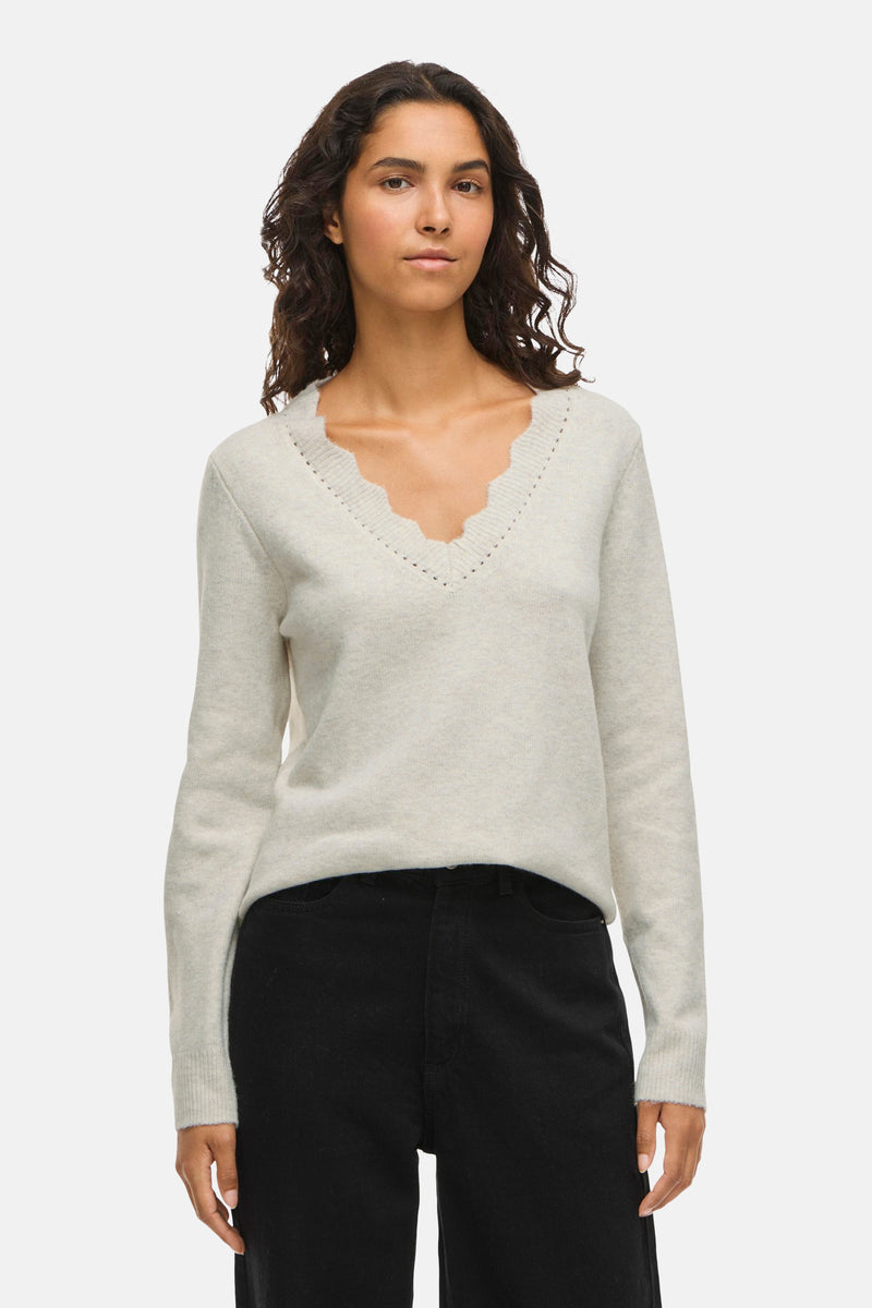 Beige V-hals trui van VILA, met geschulpte rand en perforatiedetails bij de halslijn.