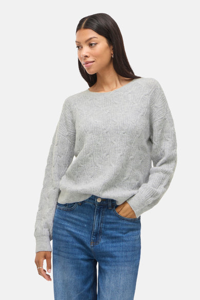 Pull à col rond gris de VILA, orné de motifs torsadés, porté avec un jean bleu.
