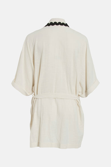 Gilet beige de VILA, avec encolure festonnée noire et manches courtes à revers.