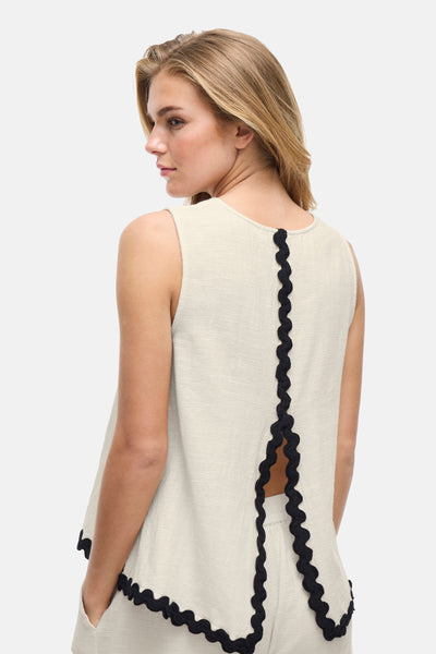 Blouse écru sans manches de VILA ornée de détails festonnés noirs et d'une ouverture au dos.